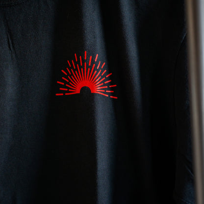Black shirt with a red logo on a dark background