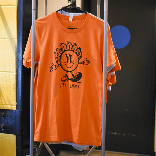 Stay Sunny Orange Tshirt featured on a rack
