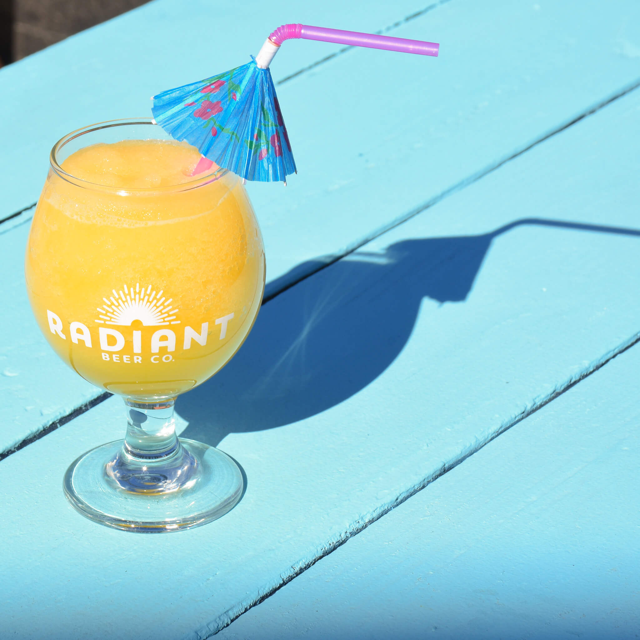Yellow beer slushie with an umbrella