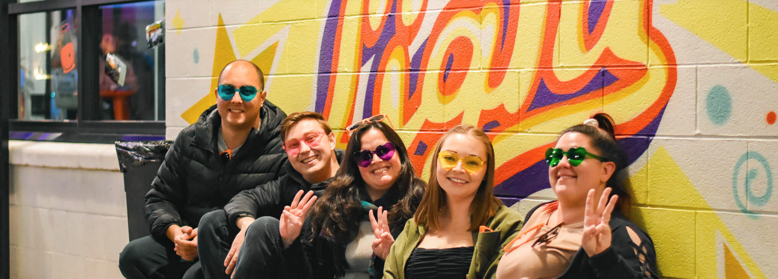 Customers sit in front of the mural on First Friday